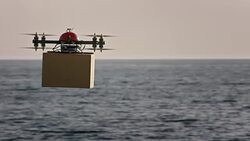 SLO MO UAV delivering package above sea surface in sunshine Stock Footage
