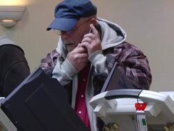MS Shot of male voter casts ballot at copmuter terminal talking on cell phone during voting in presidential election / Toledo, Ohio, United States Stock Footage