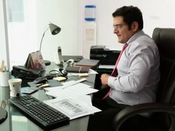 Businessman working on a mobile phone in an office  Stock Footage