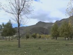 WS PAN Shot of resident and pile of Mani stones in mountain valley / China Stock Footage