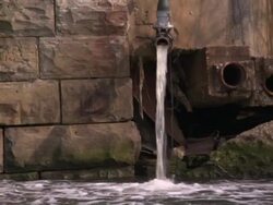 Water spills from a spout and into a stone fountain. Stock Footage