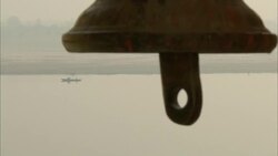 The wind blows a bell over a river in India. Stock Footage