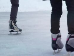 People skating away through a sun flare (Loopable) Stock Footage