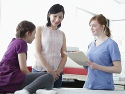 Nurse talking with patient and mother in office Stock Footage