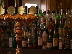 Spirits and Alcohol in bar behind brass beer taps, Lough Erne, Northern Ireland Stock Footage