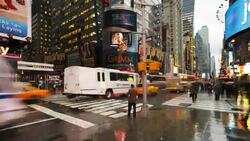Traffic and pedestrians cross a busy intersection on 42nd street near Times Square in New York City on a rainy evening. Stock Footage