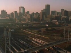 Aerial shot passing the Nelson Mandela Bridge, a railway and the Johannesburg Central Business District Stock Footage