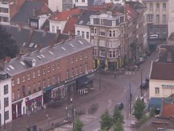 Pedestrians and light traffic travel along a street in Antwerp, Belgium. Stock Footage