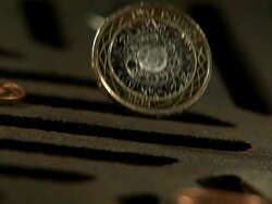 Money Down the Drain - High speed English two pound coin falling on and in to road drain, low angle, BCU Stock Footage