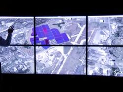 Man manipulates large array of computer wall monitors of Pecan Street Inc. Stock Footage