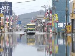 Destruction caused by tsunami after magnitude 9 Tohoku earthquake, north east Japan, March 2011. Trucks drive through tidal flooding in Ishinomaki, Miyagi Prefecture after tsunami Stock Footage