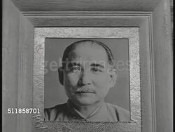 1936: CHINA: Chinese Nationalist Party flag (sun) waving on pole. Sun Yat-sen photograph. Chinese military & political leader Chiang Kai-shek (1887-1975, Generalissimo) in profile, standing w/ large unidentified man, turning back.  Kuomintang (KMT) Instructional Video