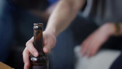Man placing beer bottle on table Stock Footage
