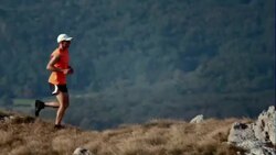 Trail runner on top of a grassy plateau Stock Footage