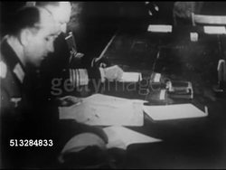 1945: GERMANY SURRENDER: VS German Nazi General Alfred Jodl at table signing paper, VS Allied officers at signing, General George C. Marshall FG table. Standing: Lieutenant General W.B. Smith, General Eisenhower, RAF Air Marshal Arthur Tedder. Instructional Video