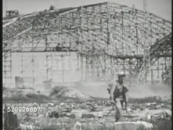 1945: OKINAWA, JAPAN: US Marines riding on tank, walking in front of burned hangar. Soldier looking at burlap covered 'dummy' Japanese aircraft on field. WS Destroyed aircraft on airfield. Pacific Theater, WWII, World War II. Instructional Video