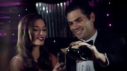 Glamorous couple pour champagne and clink glasses in backseat of limousine at awards show Stock Footage