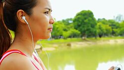 Asian Woman listen music in nature Stock Footage