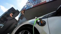 HD: Businessman On The Phone Charging His Car Stock Footage