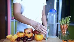 Woman walking from kitchen & drinking water in/ healthy lifestyle conceptual Stock Footage