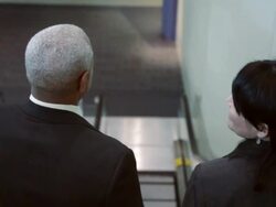 HA Business associates talking and riding down an escalator, smiling behind them, then stepping off escalator and walking away / Seattle, Washington, United States Stock Footage