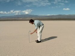 Man using faucet in desert landscape and finding there is no water Stock Footage