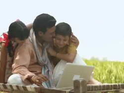 Farmer working on a laptop with his children playing with him  Stock Footage