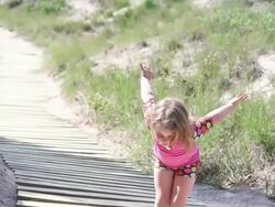 MS Little girl practicing her ballerina moves and then skiping away up boardwalk / Toronto, Ontario, Canada Stock Footage