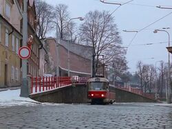 Wide shot cable car traveling along cobblestone road and turning / Prague, Czech Republic Stock Footage
