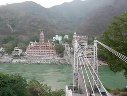 WS PAN View of Lakshman Jhula with holy city at waterfront / Rishikesh, Uttarakhand, India Stock Footage