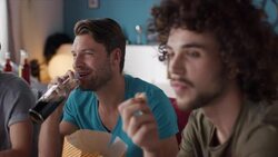 Guys sitting on couch watching tv Stock Footage