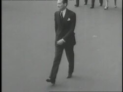 New York City Mayor Jimmy Walker places his hat on his head while walking in a parade. News Clip