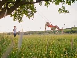 SLO MO Mother and daughter playing on tree swing Stock Footage