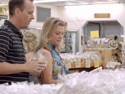 MS middle-aged couple shopping in health food store holding packs of fresh nuts in their hands and trying to decide which ones to buy / Cabazon, California, USA Stock Footage