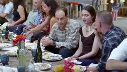 MS PAN TU Group of friends and family talking and laughing while dining at banquet table in rustic building Stock Footage