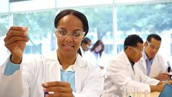 Beautiful chemistry student or chemist drops liquid into test tube Stock Footage