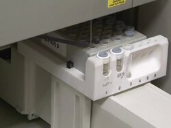 Medium hand-held pan-right - A technician loads a tray of samples into a an incubation chamber. / USA Stock Footage