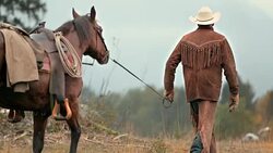 SLO MO DS  Rancher leading his horse Stock Footage