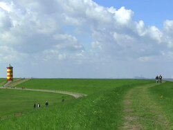 WS People enjoing at Pilsum lighthouse and wind mills near Krummhorn at North Sea (Eastern Friesland) / Lower Saxony Stock Footage
