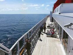 MS Shot of People walking and standing on board cruise ship Queen Mary 2, Cunard Line / North Sea, Jutland, Denmark Stock Footage