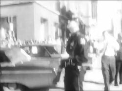B/W 1963 policeman holding gun looking up outdoors / Kennedy assassination / Dallas Stock Footage