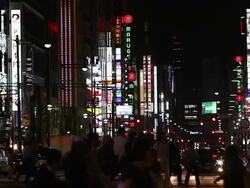 MS Shot of Busy city scene with pedestrians and traffic at night with street lights and neon retail signs in Ginza / Tokyo, Japan Stock Footage