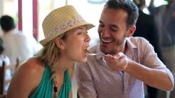 Young man feeds girlfriend a bite of his food in Brazilian restaurant Stock Footage