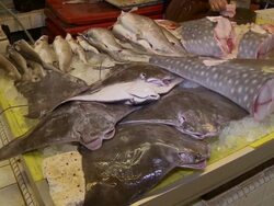 CU Dead cow nose rays and chopping up whale shark carcass on fish market counter / Brunei, Brunei Darussalam Stock Footage