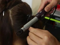 Hair stylist making curls woman's hairs Stock Footage