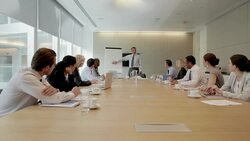 Businessman at flipchart leading meeting in conference room Stock Footage
