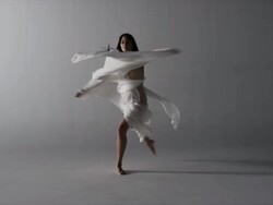 woman draped with silk runs elegantly towards camera then performs pirouettes Stock Footage
