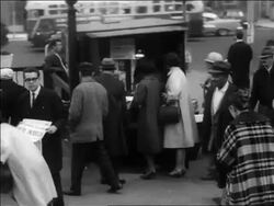 B/W 1963 people buying + reading newspapers at newsstand on sidewalk after JFK's assassination Stock Footage