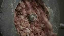 A meat grinder churns out sausage in a sausage making plant. Stock Footage