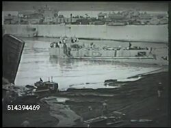 1943: ALEUTIAN ISLANDS CAMPAIGN: KISKA INVASION:  VS United States forces, including 7th Infantry Division, landing on Kiska beach, unloading supplies, tractor moving onto beach, stockpiles of boxes, crates. WWII, World War II, Pacific Front Instructional Video